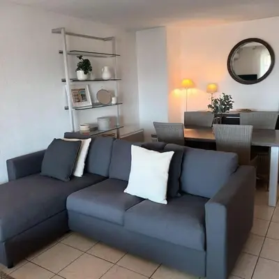 a living room with a blue couch and a table at Apt calme 2 chambres vue dégagée in Cannes