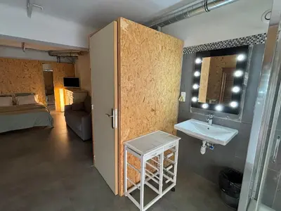 a bathroom with a sink and a room with a bed at Radiance Private Bedroom & Breakfast in Cannes