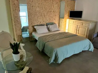 a bedroom with a bed with a table and a tv at Radiance Private Bedroom & Breakfast in Cannes