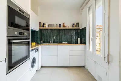 a kitchen with white cabinets and a washer and dryer at Elegance and Refinement, proximity to La Croisette in Cannes