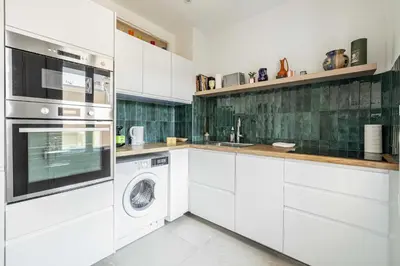 a kitchen with white cabinets and a washer and dryer at Elegance and Refinement, proximity to La Croisette in Cannes