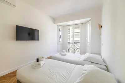 two beds in a room with a tv on the wall at Elegance and Refinement, proximity to La Croisette in Cannes