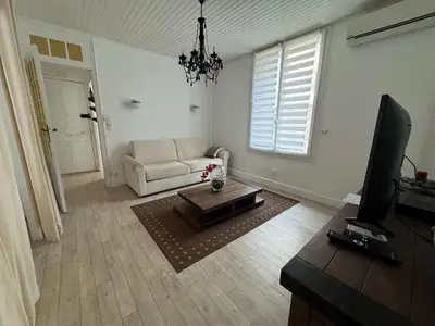 a living room with a white couch and a television at C090 Appartement confortable proche du Suquet et du Palais des festivals in Cannes