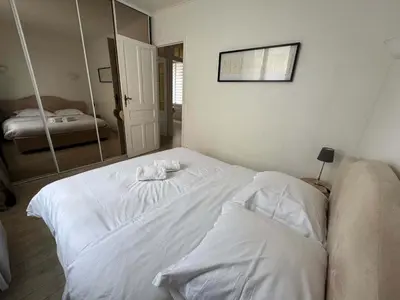 a white bed in a room with a mirror at C090 Appartement confortable proche du Suquet et du Palais des festivals in Cannes