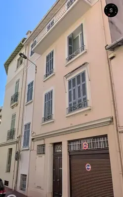 a large white building with a garage at C090 Appartement confortable proche du Suquet et du Palais des festivals in Cannes