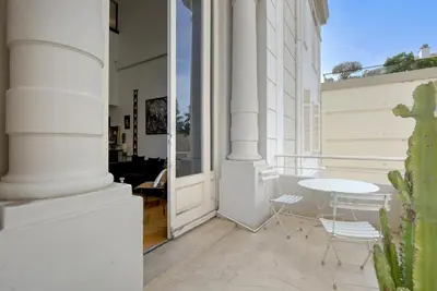 a balcony with a table and chairs on a building at Triplex Gallia Luxe Cannes in Cannes