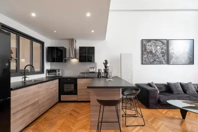 a kitchen and living room with a couch and a table at Triplex Gallia Luxe Cannes in Cannes
