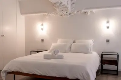 a white bed with a towel on top of it at Triplex Gallia Luxe Cannes in Cannes