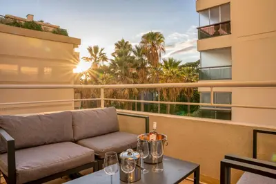 a balcony with a couch and a table with wine glasses at Triplex Gallia Luxe Cannes in Cannes