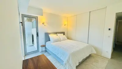 a bedroom with a white bed and a mirror at Verdalia luxury 3 bedroom by Welcome to Cannes in Cannes