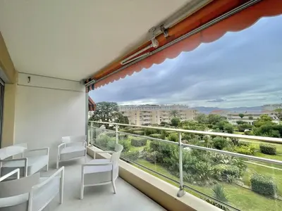 a balcony with white chairs and a large window at Verdalia luxury 3 bedroom by Welcome to Cannes in Cannes