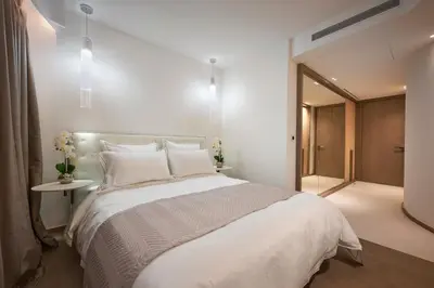 a bedroom with a large white bed and a hallway at First Croisette in Cannes
