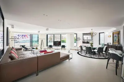 a living room with a large couch and a dining room at First Croisette in Cannes