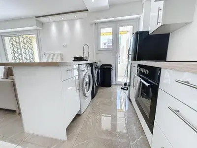 a white kitchen with a washer and dryer in it at INTUITION - 3 pieces - 10min Croisette in Cannes