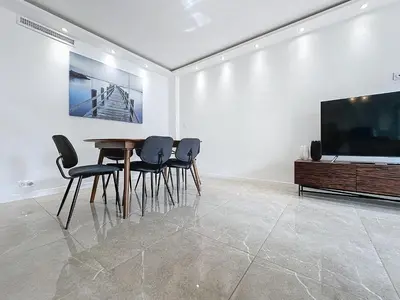 a dining room with a table and chairs and a flat screen tv at INTUITION - 3 pieces - 10min Croisette in Cannes