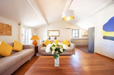 a living room with a couch and a vase of flowers at Exquisite 2-Br apartment 3 minutes from la Croisette in Cannes