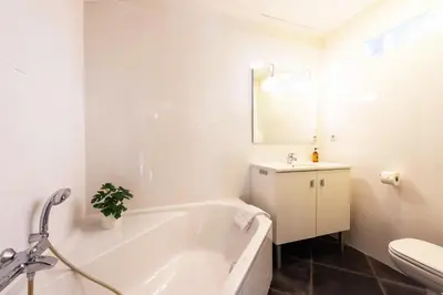 a white bathroom with a tub and a toilet at Exquisite 2-Br apartment 3 minutes from la Croisette in Cannes