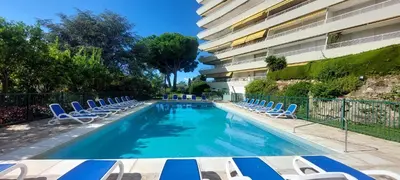a swimming pool with lounge chairs and a building at Les Orangers - Cannes - Sea View- Swimming Pool - Free Parking - Beach in Cannes