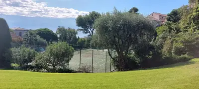 a tennis court in the middle of a field at Les Orangers - Cannes - Sea View- Swimming Pool - Free Parking - Beach in Cannes