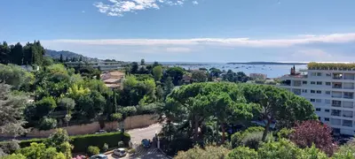 a view of a city with trees and a building at Les Orangers - Cannes - Sea View- Swimming Pool - Free Parking - Beach in Cannes