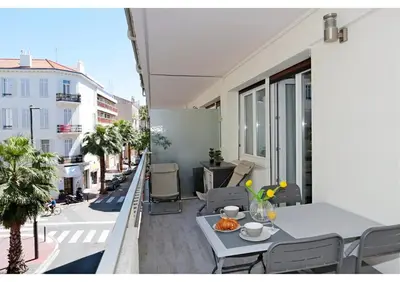 a balcony with a table and chairs on a building at T2 centre-ville Banane à Cannes avec grande terrasse in Cannes