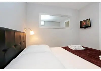 a white bathroom with a sink and a room with a bed at T2 centre-ville Banane à Cannes avec grande terrasse in Cannes
