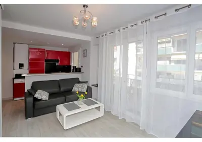 a living room with a black couch and a table at T2 centre-ville Banane à Cannes avec grande terrasse in Cannes