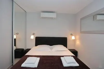 a white room with a bed and a tv at T2 centre-ville Banane à Cannes avec grande terrasse in Cannes
