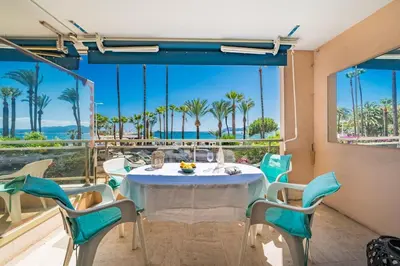 a table and chairs on a balcony with a view of the ocean at Croisette vue mer 2 pièces in Cannes
