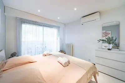 a white bedroom with a large bed with towels on it at Croisette vue mer 2 pièces in Cannes