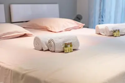 two rolls of towels and two bottles on a bed at Croisette vue mer 2 pièces in Cannes