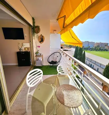 a balcony with a table and chairs and a television at New top floor avec vue mer, Croisette à Palm Beach in Cannes