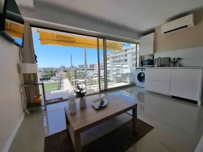 a living room with a table and a large window at New top floor avec vue mer, Croisette à Palm Beach in Cannes