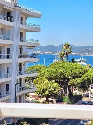 a large apartment building with trees in front of the water at New top floor avec vue mer, Croisette à Palm Beach in Cannes