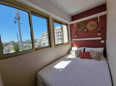a bedroom with a bed and two windows at New top floor avec vue mer, Croisette à Palm Beach in Cannes
