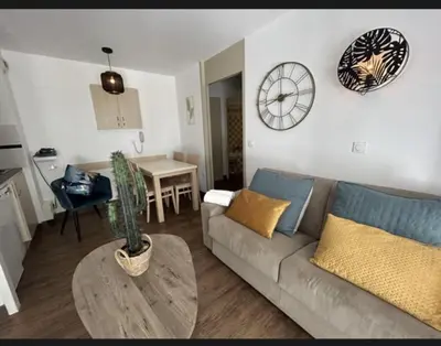 a living room with a couch and a clock on the wall at Le cannois in Cannes