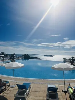 a pool with chairs and umbrellas in front of the water at Le cannois in Cannes