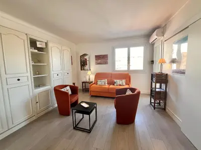 a living room with an orange couch and two chairs at Le Petit Magellan by Welcome to Cannes in Cannes