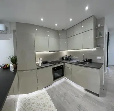 a kitchen with white cabinets and a black counter top at Luxurious 3Bedroom 2 BATH 110 m Apartment Adjoining Hotel Martinez Beachfront in Cannes