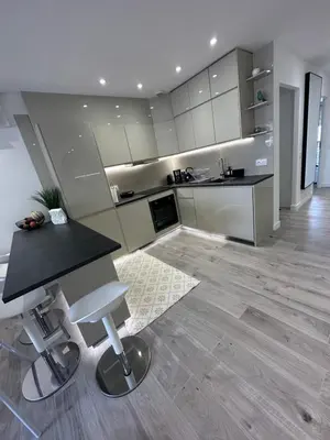 a kitchen with a counter and a table and a stool at Luxurious 3Bedroom 2 BATH 110 m Apartment Adjoining Hotel Martinez Beachfront in Cannes