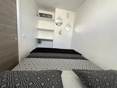 a small bedroom with a bed and white walls at Appartement cosy à 2 pas de la Croisette in Cannes