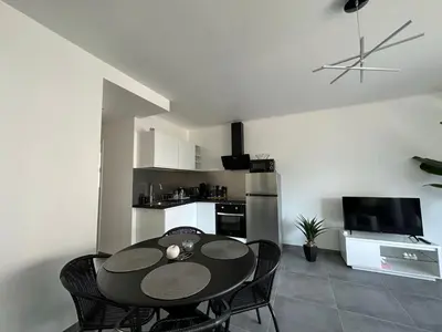 a kitchen and dining room with a table and chairs at Appartement cosy à 2 pas de la Croisette in Cannes