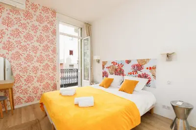 a bedroom with a large bed with an orange blanket at Nasturtium YourHostHelper in Cannes