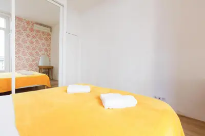 a yellow bed with two towels on top of it at Nasturtium YourHostHelper in Cannes