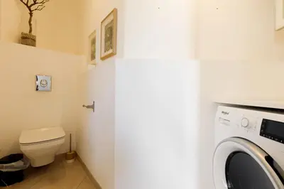 a bathroom with a toilet and a washing machine at Nasturtium YourHostHelper in Cannes