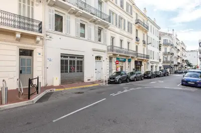 a street with cars parked on the side of a building at Nasturtium YourHostHelper in Cannes