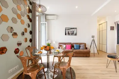 a living room with a table and chairs and a couch at Nasturtium YourHostHelper in Cannes