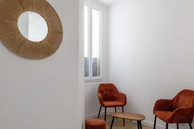 a room with two chairs and a mirror on the wall at LE LOGIS CANNOIS au calme en centre-ville in Cannes