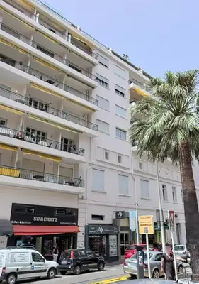 a large white building with a palm tree in front of it at Superbe T2 lumineux dans le centre CIO1899 in Cannes