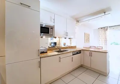 a kitchen with white cabinets and a sink at Viva Riviera -14 Avenue Isola Bella in Cannes